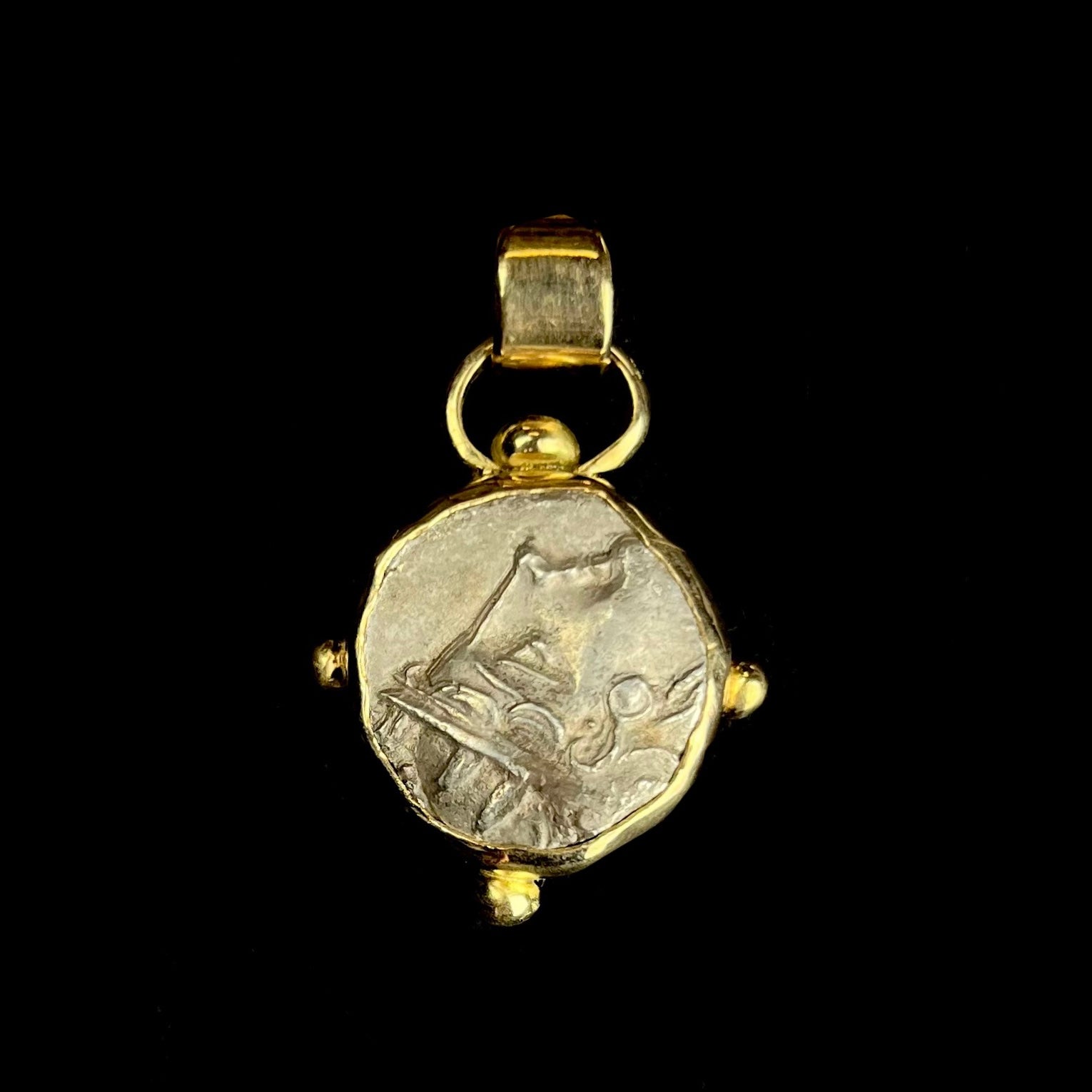 Pendant with face of Athena looking upward to bail