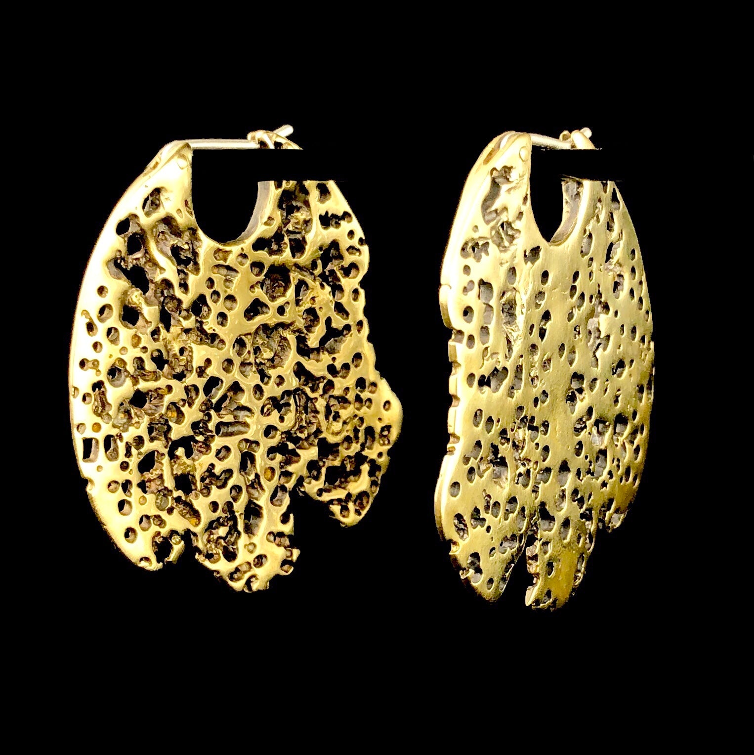 Large brass sail shaped earrings with lots of small holes like old wood