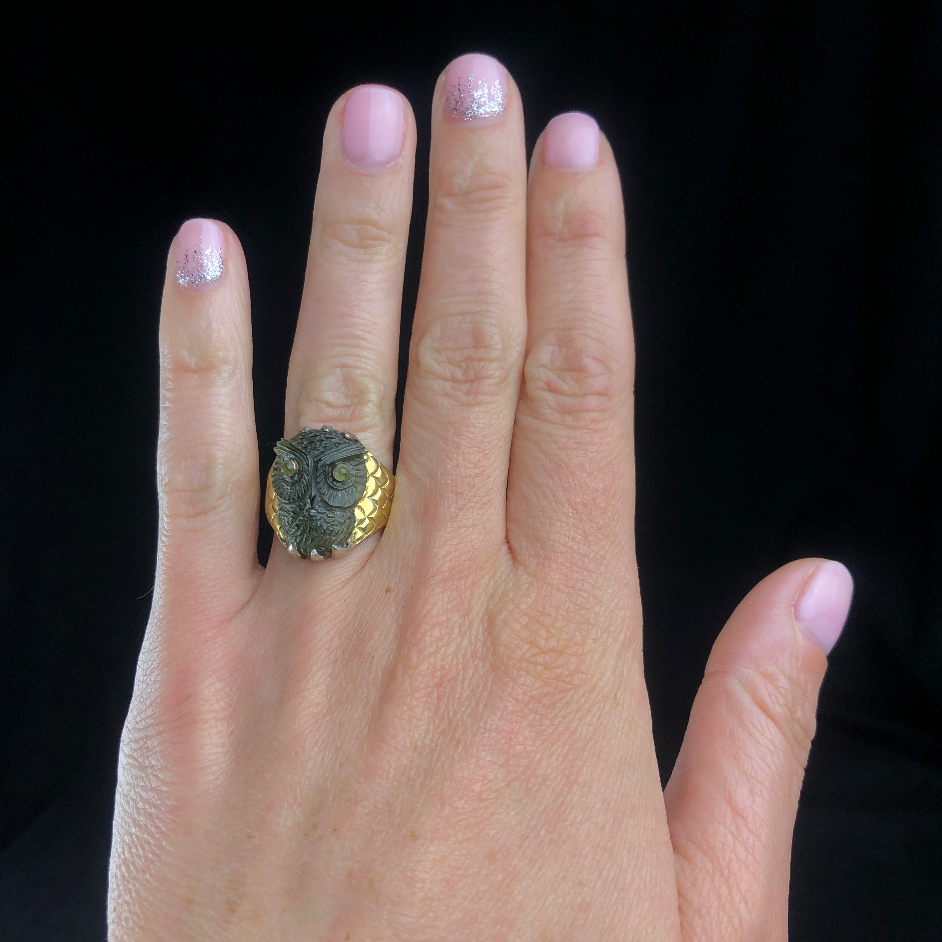 Green carved owl on gold and silver band shown on hand