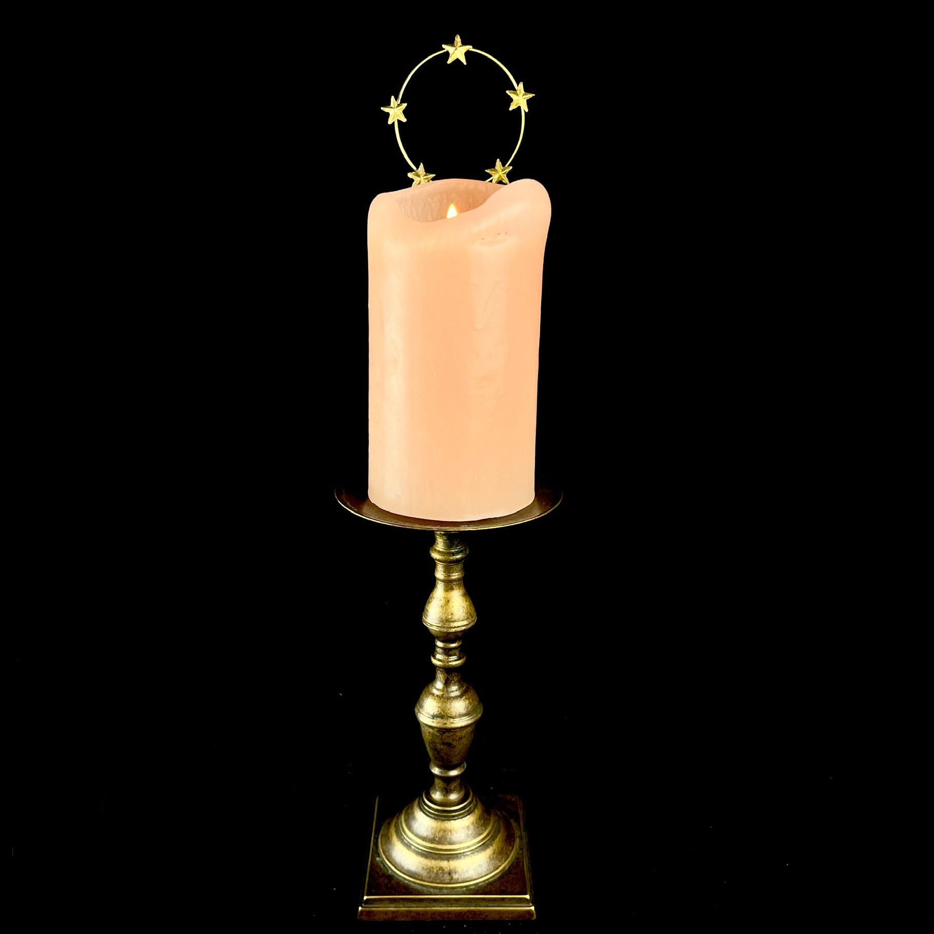 Star Halo Charm shown on pink candle with lit flame